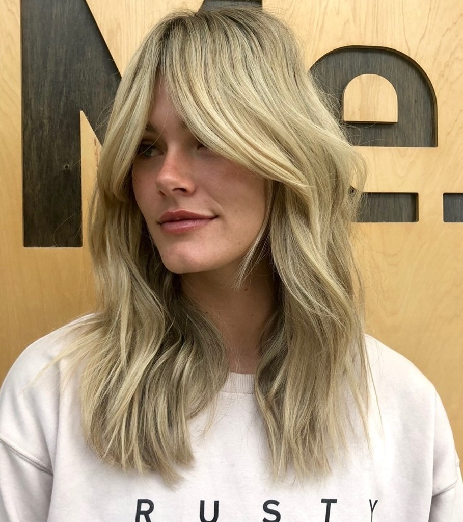 Medium Blonde Hairstyle with Bangs and Soft Wave